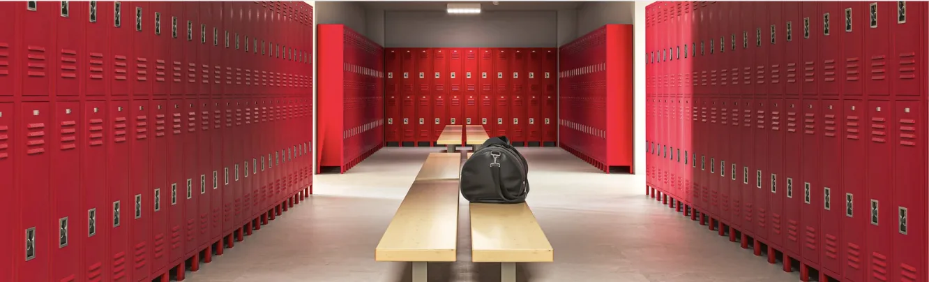 Vestiaire aux casiers rouges, un sac de sport posé seul sur un banc